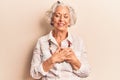 Senior grey-haired woman wearing casual clothes smiling with hands on chest with closed eyes and grateful gesture on face Royalty Free Stock Photo