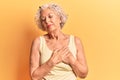 Senior grey-haired woman wearing casual clothes smiling with hands on chest with closed eyes and grateful gesture on face Royalty Free Stock Photo