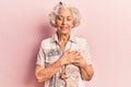 Senior grey-haired woman wearing casual clothes smiling with hands on chest with closed eyes and grateful gesture on face Royalty Free Stock Photo