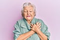 Senior grey-haired woman wearing casual clothes smiling with hands on chest, eyes closed with grateful gesture on face Royalty Free Stock Photo