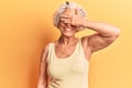 Senior grey-haired woman wearing casual clothes smiling and laughing with hand on face covering eyes for surprise Royalty Free Stock Photo