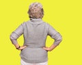 Senior grey-haired woman wearing casual winter sweater standing backwards looking away with arms on body Royalty Free Stock Photo