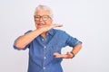 Senior grey-haired woman wearing denim shirt and glasses over isolated white background gesturing with hands showing big and large Royalty Free Stock Photo