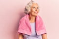 Senior grey-haired woman wearing sportswear and towel looking to side, relax profile pose with natural face and confident smile Royalty Free Stock Photo
