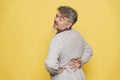 Senior grey man with backache rubbing his back Royalty Free Stock Photo