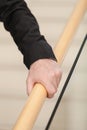 Senior Hand Grasps Wooden Railing