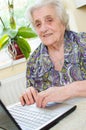 The senior hand presses the laptop keyboard