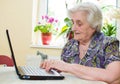 The senior hand presses the laptop keyboard