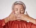 Senior, hands and mouth of an elderly woman covering her teeth or lips with hand against a grey studio background Royalty Free Stock Photo