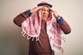 Senior handsome arab man wearing keffiyeh standing over isolated white background suffering from headache desperate and stressed Royalty Free Stock Photo