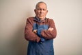 Senior handsome baker man wearing apron standing over isolated white background skeptic and nervous, disapproving expression on Royalty Free Stock Photo