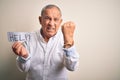 Senior handsome businessman holding paper help message over isolated white background annoyed and frustrated shouting with anger, Royalty Free Stock Photo