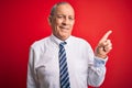 Senior handsome businessman wearing elegant tie standing over isolated red background with a big smile on face, pointing with hand Royalty Free Stock Photo