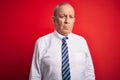 Senior handsome businessman wearing elegant tie standing over isolated red background depressed and worry for distress, crying Royalty Free Stock Photo