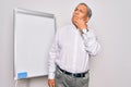 Senior handsome grey-haired businessman doing presentation using magnetic board with hand on chin thinking about question, pensive Royalty Free Stock Photo