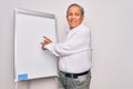Senior handsome grey-haired businessman doing presentation using magnetic board smiling and looking at the camera pointing with Royalty Free Stock Photo