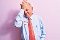 Senior handsome grey-haired businessman wearing tie and shirt with name presentation sticker surprised with hand on head for