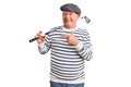 Senior handsome grey-haired man holding golf club and ball smiling happy pointing with hand and finger Royalty Free Stock Photo