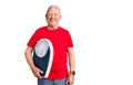 Senior handsome grey-haired man holding weighing machine looking positive and happy standing and smiling with a confident smile Royalty Free Stock Photo