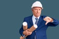 Senior handsome grey-haired man wearing architect hardhat holding blueprints with angry face, negative sign showing dislike with Royalty Free Stock Photo