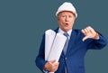 Senior handsome grey-haired man wearing architect hardhat holding blueprints with angry face, negative sign showing dislike with Royalty Free Stock Photo