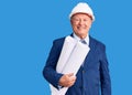 Senior handsome grey-haired man wearing architect hardhat holding blueprints looking positive and happy standing and smiling with Royalty Free Stock Photo
