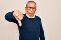 Senior handsome grey-haired man wearing sweater and glasses over isolated white background looking unhappy and angry showing Royalty Free Stock Photo