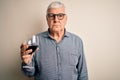 Senior handsome hoary man drinking glass of red wine over isolated white background with a confident expression on smart face Royalty Free Stock Photo