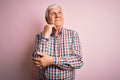 Senior handsome hoary man wearing casual colorful shirt over isolated pink background with hand on chin thinking about question,