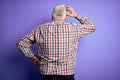 Senior handsome hoary man wearing casual colorful shirt over isolated purple background Backwards thinking about doubt with hand