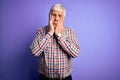 Senior handsome hoary man wearing casual colorful shirt over isolated purple background Tired hands covering face, depression and Royalty Free Stock Photo