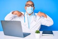 Senior handsome man with gray hair wearing doctor uniform and medical mask looking confident with smile on face, pointing oneself Royalty Free Stock Photo