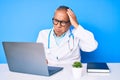Senior handsome man with gray hair wearing doctor uniform working using computer laptop confuse and wonder about question Royalty Free Stock Photo