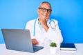 Senior handsome man with gray hair wearing doctor uniform working using computer laptop with hand on chin thinking about question, Royalty Free Stock Photo