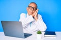 Senior handsome man with gray hair wearing doctor uniform working using computer laptop sleeping tired dreaming and posing with Royalty Free Stock Photo