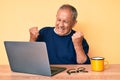 Senior handsome man with gray hair working at the office with laptop annoyed and frustrated shouting with anger, yelling crazy Royalty Free Stock Photo