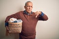 Senior handsome man holding wicker basket with clothes over isolated white background with angry face, negative sign showing Royalty Free Stock Photo