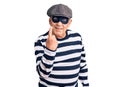 Senior handsome man wearing burglar mask and t-shirt beckoning come here gesture with hand inviting welcoming happy and smiling Royalty Free Stock Photo
