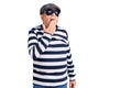 Senior handsome man wearing burglar mask and t-shirt bored yawning tired covering mouth with hand