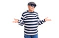 Senior handsome man wearing burglar mask and t-shirt clueless and confused expression with arms and hands raised Royalty Free Stock Photo