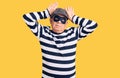 Senior handsome man wearing burglar mask and t-shirt doing bunny ears gesture with hands palms looking cynical and skeptical Royalty Free Stock Photo