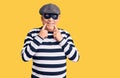 Senior handsome man wearing burglar mask and t-shirt smiling with open mouth, fingers pointing and forcing cheerful smile Royalty Free Stock Photo