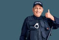 Senior handsome man wearing police uniform smiling happy and positive, thumb up doing excellent and approval sign