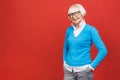 Senior happy aged businesswoman wearing glasses. Beautiful old woman looking at camera and smiling. Isolated on red background Royalty Free Stock Photo