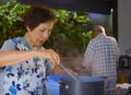 senior happy and beautiful retired Asian Japanese couple cooking together at home kitchen enjoying preparing meal relaxed
