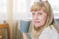 Senior happy blonde woman holding cup of coffee Royalty Free Stock Photo