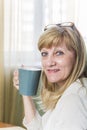 Senior happy blonde woman holding cup of coffee Royalty Free Stock Photo
