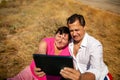 Senior happy couple having fun using digital tablet pc at beach during moment of relax Royalty Free Stock Photo