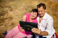 Senior happy couple having fun using digital tablet pc at beach during moment of relax Royalty Free Stock Photo