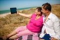 Senior happy couple having fun using digital tablet pc at beach during moment of relax Royalty Free Stock Photo